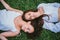 Two teenagers laying down on the grass