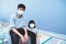 Two teenagers, a man and a woman, wear masks outside the building to prevent COVID-19 infection. Wear a mask to prevent virus infe
