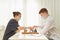 Two teenagers play chess during quarantine due to coronavirus pandemic. Boy and girl play Board games