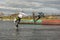 Two teenagers wakeboarders on a lake during a physical education lesson. makes an extreme jump on wakeboarding, around there are a