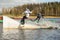 Two teenagers wakeboarders on a lake during a physical education lesson. makes an extreme jump on wakeboarding, around there are