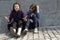 Two teens friends sitting on stone