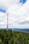 Two telecommunication towers with communication transmitters and aerials in forest