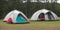 Two tents in a field with trees in the background created with Generative AI technology