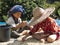 Two thai children sitting, separating cffee beans