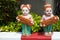 Two Thai girls ceramic figurines holding welcome sign in English and Thai