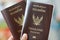 Two Thai passports in hand