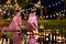 Two thai woman holding a krathong sitting on a raft by the river, Asian women in traditional Thai costumes bring krathongs to