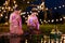 Two thai woman sitting wai on a raft by the river, Asian women in traditional Thai costumes bring krathongs to float on Loi