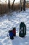 Two thermo mugs with a beverage and a large thermos in the snow.