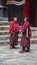 Two Tibetan Buddhist monks stand in courtyard of Tashilhunpo Monastery . Shigatse , Tibet