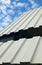 Two-tiered corrugated iron roof against cloudy sky