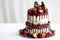 Two-tiered wedding cake in chocolate, with slices strawberries,