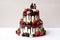 Two-tiered wedding cake in chocolate, with slices strawberries, raspberries, blackberry, decorated with figures of the bride and