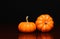 Two tiny pumpkins over black. Halloween