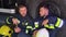 Two tired firefighters are sitting near a fire truck after a fire