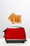 Two toasts jumping out of red toaster against white background