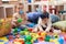 Two toddlers playing with balls and xylophone sitting on floor at kindergarten