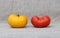 Two tomatoes. Red and yellow.