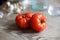Two Tomatoes on Wood with Garlic and Glasses in Background