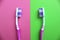 Two toothbrushes are against each other on a different background