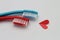Two toothbrushes in red and blue colors and a paper red heart symbolic shape. Love concept