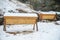 Two top bar hives covered in snow in winter.