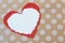 Two torn paper hearts resting on a background of polka dot kraft paper
