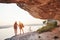 Two tourist male and woman with backpacks stand to the top of the crag and enjoying sunrise. Traveling mountains and