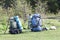 Two touristic hikers backpacks standing in a mountain valley on