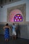 Two tourists admire colored window in El Bahia Palace in Marrakesh