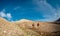 Two tourists with backpacks in the mountains. Tourists travel through the rocky mountains. Active rest in mountain hiking.