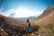 Two tourists with backpacks in the mountains. Tourists travel through the rocky mountains. Active rest in mountain hiking.