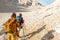 Two tourists with backpacks in the mountains. Tourists travel through the rocky mountains. Active rest in mountain hiking.