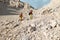 Two tourists with backpacks in the mountains. Tourists travel through the rocky mountains. Active rest in mountain hiking.