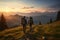 Two tourists with backpacks traveling in the mountains at the top in the rays of the sun at sunrise or sunset