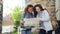 Two tourists are looking at map standing in the street holding bicycles and talking. Attractive young women and casual