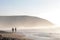 Two tourists walk along the coast of Legzira beach.