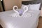 Two towel swans shaped on the bed