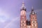 Two towers of the St Mary Basilica in Krakow against the background of a fantastic purple sky and a rainbow