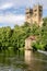 Two towers sticking up through a forest and a boat house