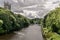 Two towers sticking up through a forest and a stone bridge