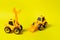 Two toy cars are yellow tractors of lumber loaders. Bright photo for the toy store