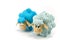 Two toy lambs, one focused turquoise speckled second blue speckled not in focus on white background
