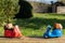 Two toy scooters on wooden surface against background of green grass. Concept of travel, delivery, travel