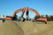 Two tracked orange excavators prepared for work