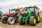 Two tractors tractors parked up with hay bales
