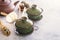 Two traditional Chinese porcelain green tea cups stand on a gray table.