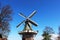 Two traditional Dutch windmills with tulips rows at spring day, Netherlands