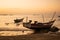 Two traditional wooden boats in a bright orange sunset, Ngwesaung, Myanmar